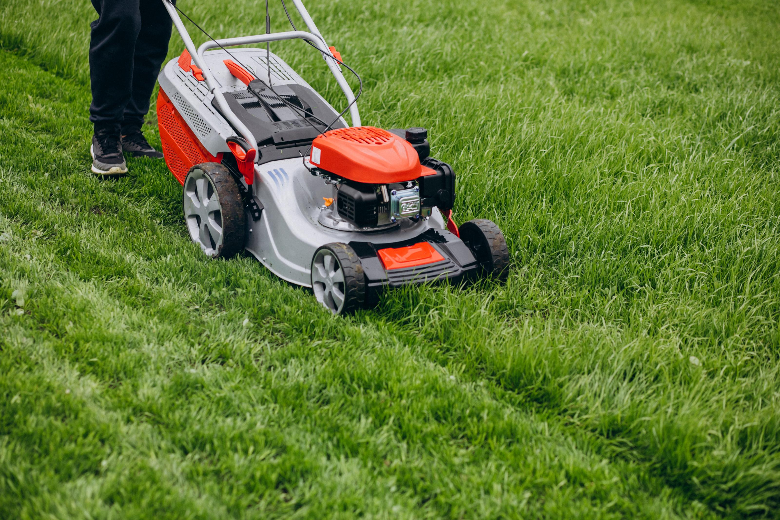 man-cutting-grass-with-lawn-mover-in-the-back-yard